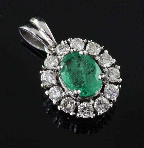 A white gold, emerald and diamond cluster pendant, overall 0.75in.